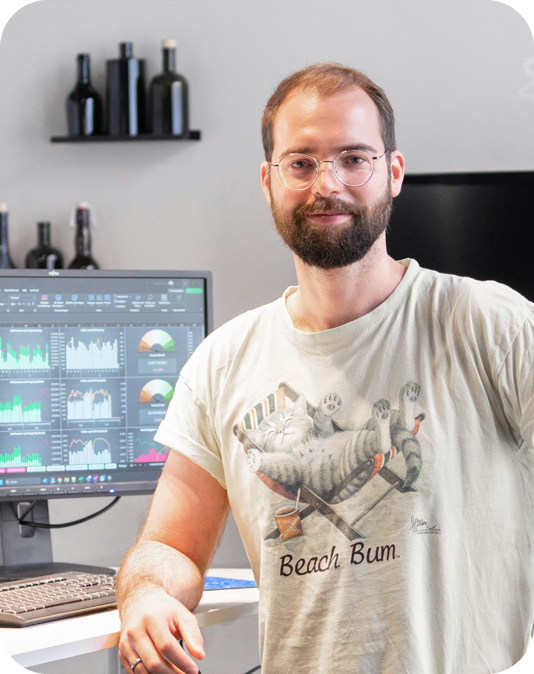 Lächelnder Mann steht vor seinem Schreibtisch