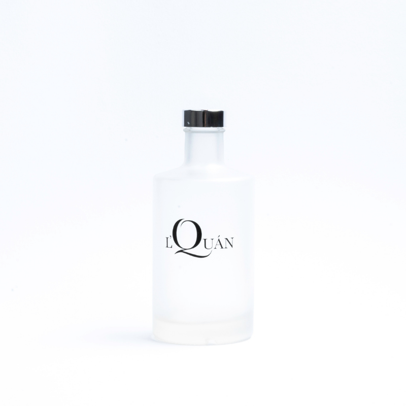 Mattierte Zylinderflasche Logo L'Quán Produktbeispiel: mattierte Glasflasche Caroline mit schwarzem Logo-Druck von L'Quán
